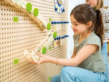 Plug It Kugelbahn-Set mit spielenden Kindern am Plug it Wandsystem Plug It Kugelbahn-Set mit spielenden Kindern am Plug it Wandsystem