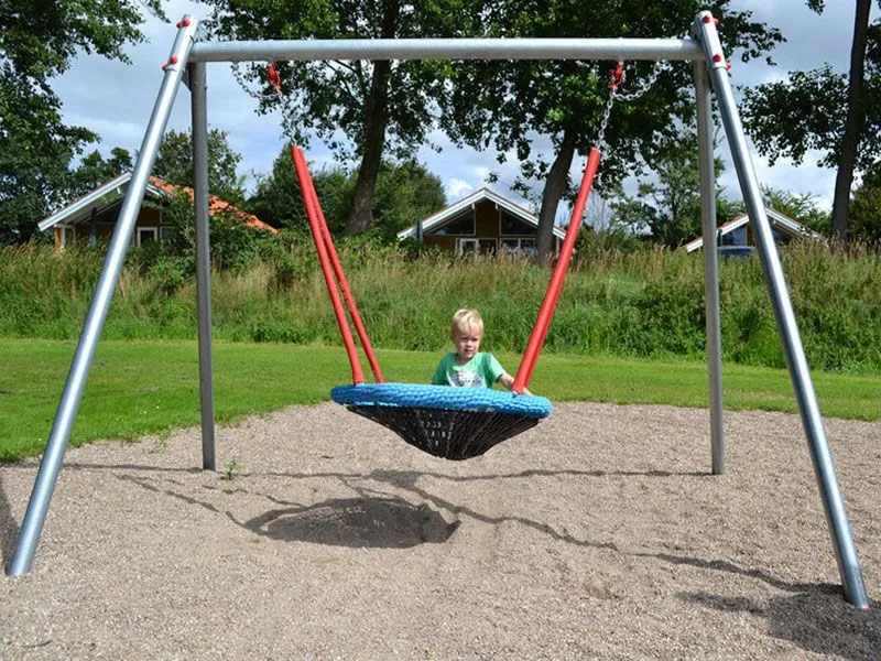 Vogelnestschaukel auf dem Spielplatz mit schaukelndem Kind