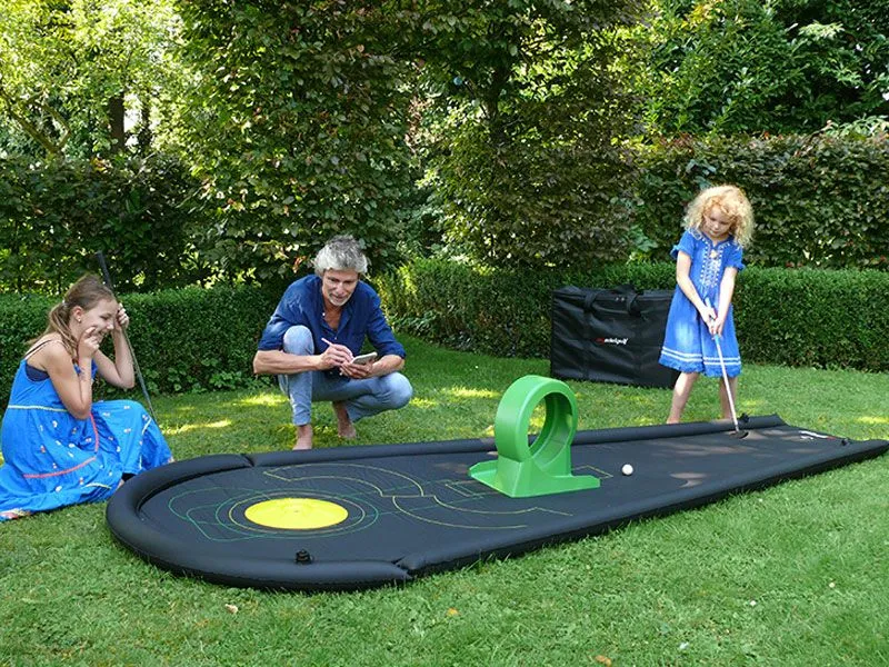 Airtrack mini golf course in the garden with children Airtrack mini golf course in the garden with children