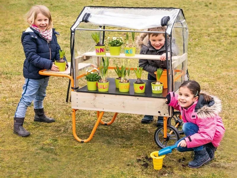 Mobile greenhouse with happy children in the garden Mobile greenhouse with happy children in the garden