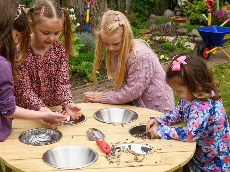 Outdoor round experimental and sand play table with accessories and children at play Outdoor round experimental and sand play table with accessories and children at play