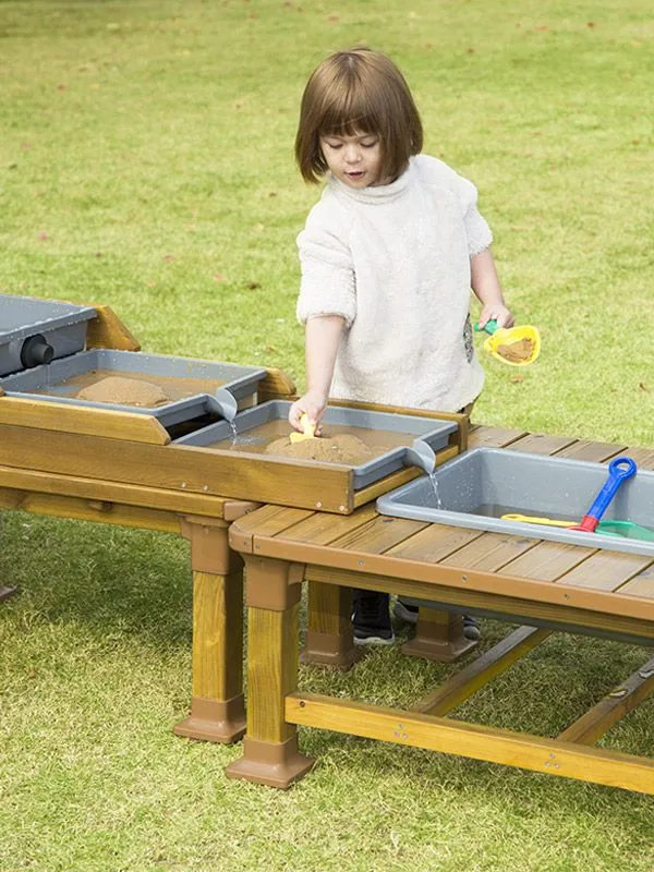 fröhlich spielendes Mädchen am Wasserfall-Tisch fröhlich spielendes Mädchen am Wasserfall-Tisch