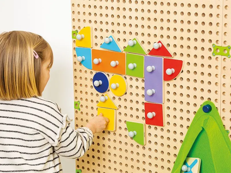 Plug It Fröbel-Set mit spielendem Kind am Plug it Wandsystem