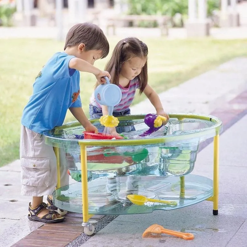 Sand- und Wasserspieltisch, Klarsicht mit fröhlich spielenden Kindern Sand- und Wasserspieltisch, Klarsicht mit fröhlich spielenden Kindern
