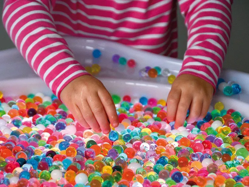 Water pearl sensor beads colorful in light table tub with child
