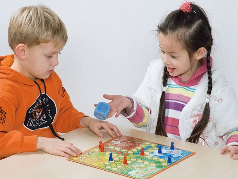 Wild dice with happy children playing the classic board game Wild dice with happy children playing the classic board game